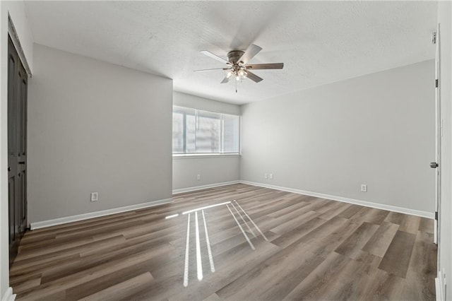 unfurnished bedroom with ceiling fan, dark hardwood / wood-style flooring, and a textured ceiling