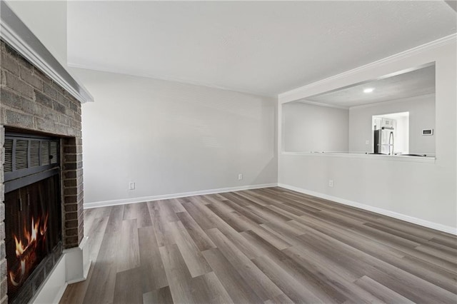 unfurnished living room featuring a fireplace, light hardwood / wood-style flooring, and ornamental molding