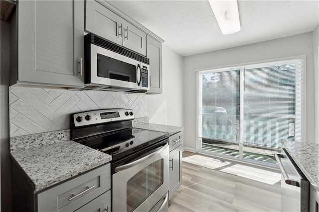 kitchen with stainless steel appliances, a healthy amount of sunlight, and gray cabinetry