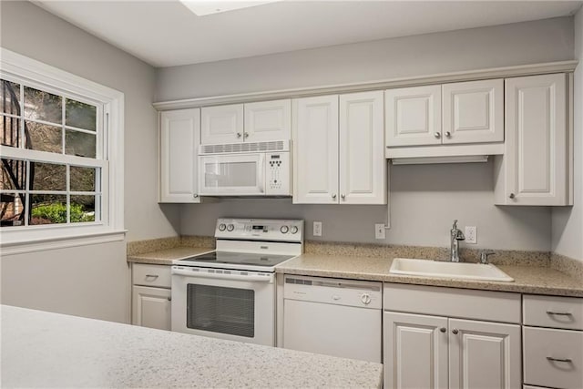 kitchen featuring light countertops, white appliances, a sink, and white cabinets