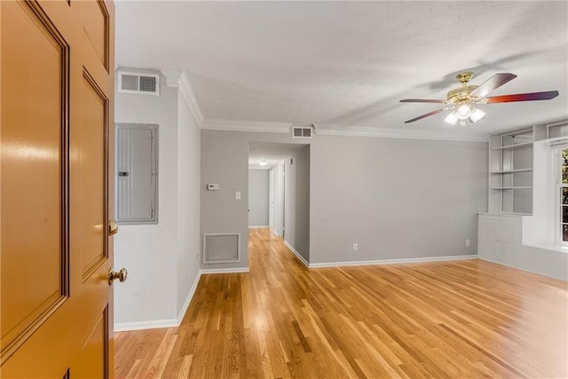 unfurnished room with electric panel, visible vents, and light wood finished floors