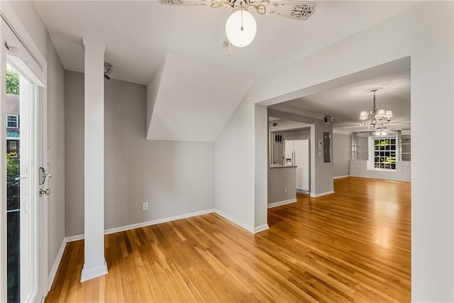 bonus room featuring light wood-style flooring, baseboards, vaulted ceiling, and a notable chandelier