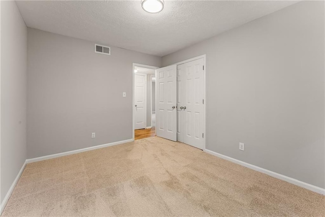 unfurnished bedroom featuring carpet flooring, visible vents, and baseboards