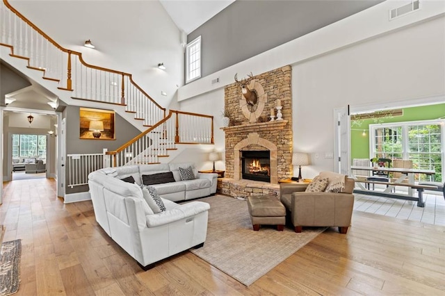4337 Mountain View Rd, Oakwood, GA 30566 - living area with high vaulted ceiling, wood-type flooring, healthy amount of natural light, and a stone fireplace