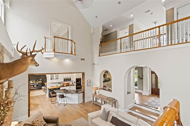 4337 Mountain View Rd, Oakwood, GA 30566 - living room with arched walkways, light wood-style flooring, a high ceiling, and recessed lighting