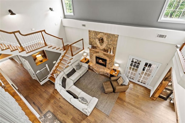4337 Mountain View Rd, Oakwood, GA 30566 - living room featuring healthy amount of natural light, a towering ceiling, wood finished floors, a stone fireplace, and stairway