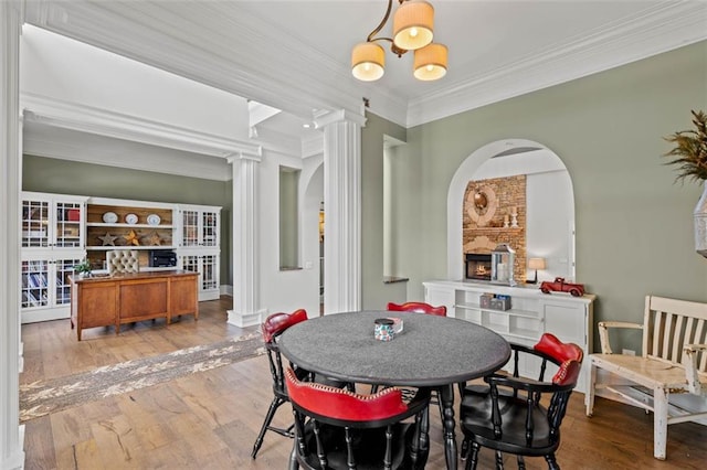 4337 Mountain View Rd, Oakwood, GA 30566 - dining space featuring decorative columns, arched walkways, wood finished floors, ornamental molding, and a fireplace