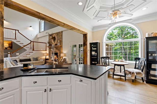 4337 Mountain View Rd, Oakwood, GA 30566 - kitchen with a fireplace, open floor plan, light wood-style floors, a ceiling fan, and crown molding