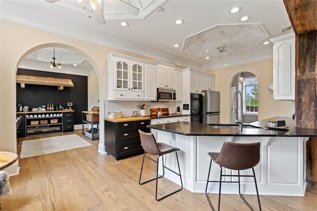 4337 Mountain View Rd, Oakwood, GA 30566 - kitchen with a ceiling fan, arched walkways, white cabinets, a kitchen breakfast bar, and crown molding