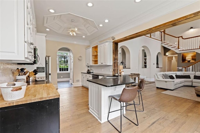 4337 Mountain View Rd, Oakwood, GA 30566 - kitchen with open shelves, a breakfast bar, arched walkways, white cabinetry, and a peninsula
