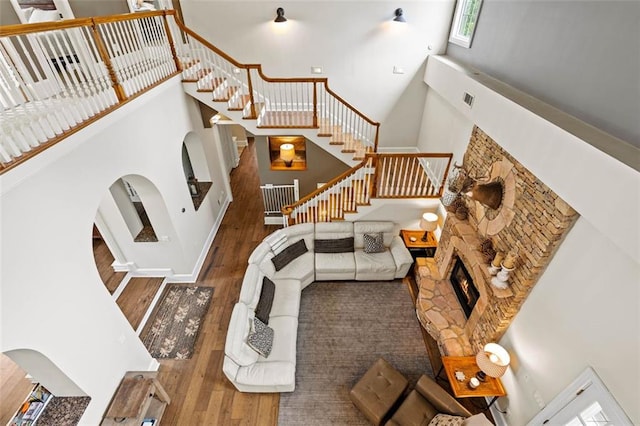 4337 Mountain View Rd, Oakwood, GA 30566 - living room with a high ceiling, hardwood / wood-style flooring, stairway, a fireplace, and arched walkways
