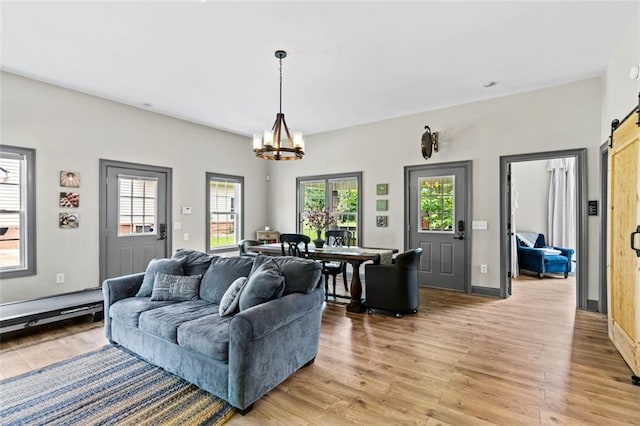 4337 Mountain View Rd, Oakwood, GA 30566 - living room featuring a chandelier, a barn door, light wood-style flooring, and plenty of natural light