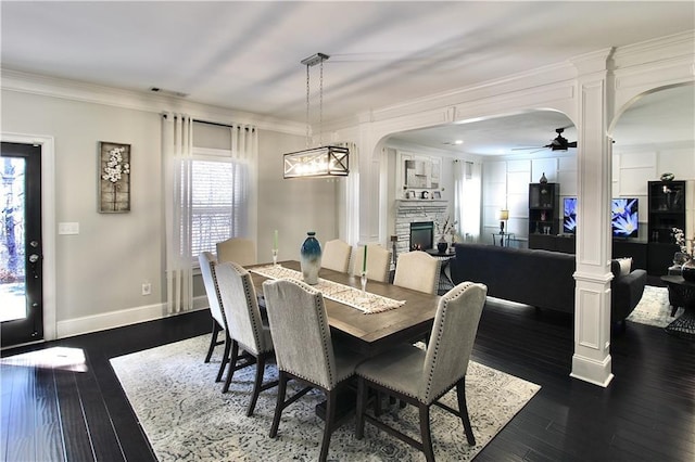 dining room featuring crown molding, a healthy amount of sunlight, and a fireplace