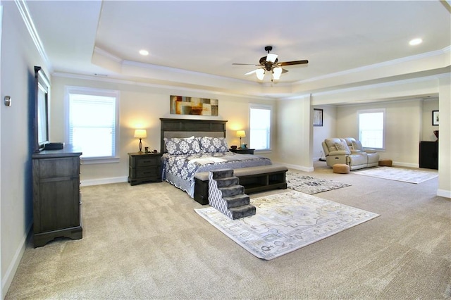 carpeted bedroom with crown molding, a tray ceiling, multiple windows, and ceiling fan