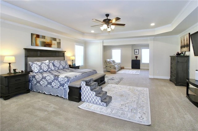 bedroom with light carpet, crown molding, a raised ceiling, and ceiling fan