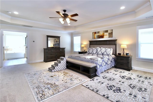 bedroom featuring a raised ceiling, ceiling fan, and multiple windows