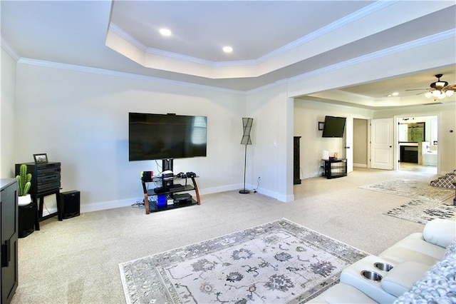 carpeted living room featuring crown molding, a tray ceiling, and ceiling fan