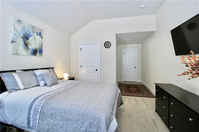 carpeted bedroom with lofted ceiling