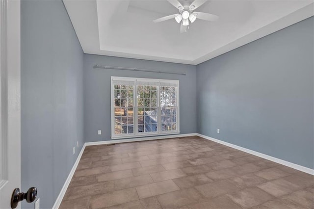 empty room with ceiling fan and baseboards