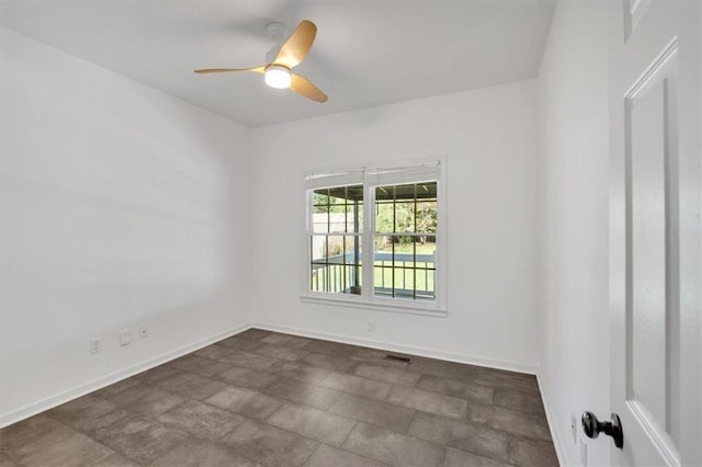 empty room featuring baseboards, stone finish flooring, ceiling fan, and visible vents