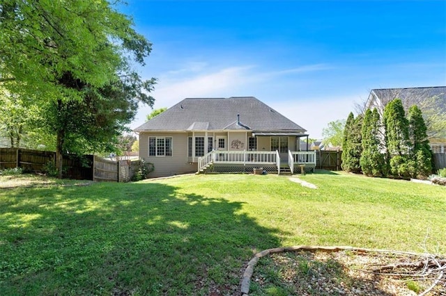 rear view of property featuring a yard, a wooden deck, and a fenced backyard