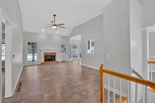 unfurnished living room featuring visible vents, a fireplace, baseboards, high vaulted ceiling, and a ceiling fan