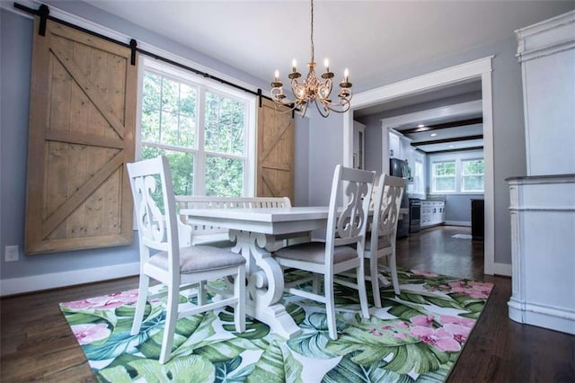 dining room with a wealth of natural light, a barn door, a chandelier, and dark wood-type flooring