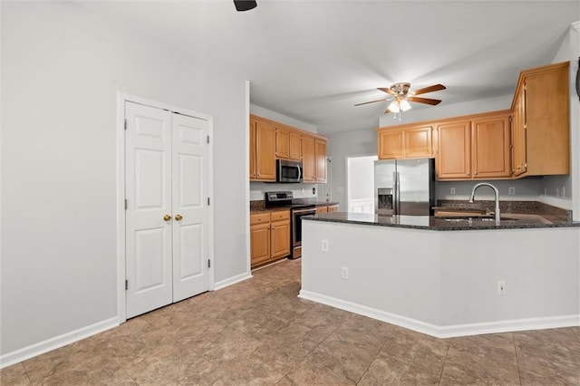 194 Lake Ruby Dr, Suwanee, GA 30024 - kitchen featuring appliances with stainless steel finishes, ceiling fan, a sink, a peninsula, and dark stone countertops