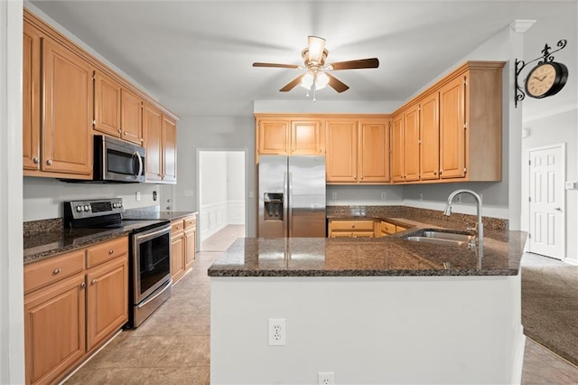 194 Lake Ruby Dr, Suwanee, GA 30024 - kitchen featuring appliances with stainless steel finishes, a sink, a ceiling fan, dark stone countertops, and a peninsula