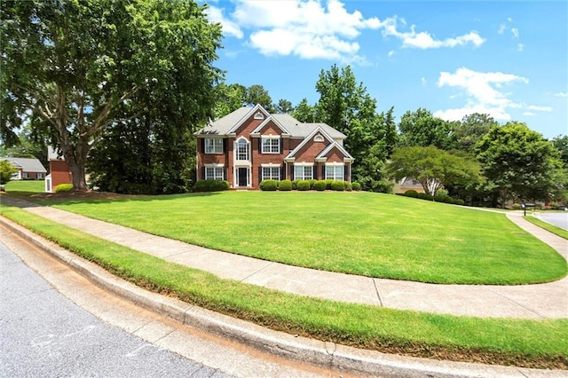 194 Lake Ruby Dr, Suwanee, GA 30024 - colonial-style house featuring a front yard and brick siding