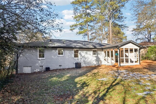 rear view of house featuring a lawn, central AC, and a sunroom