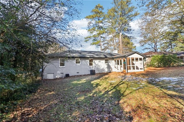 back of property featuring a yard and a sunroom