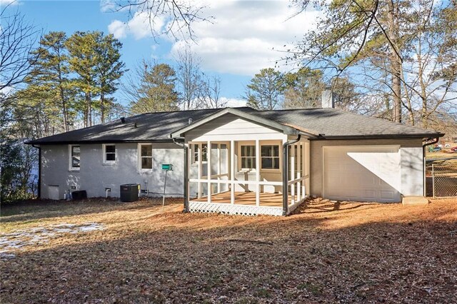 back of house featuring a sunroom, cooling unit, and a garage