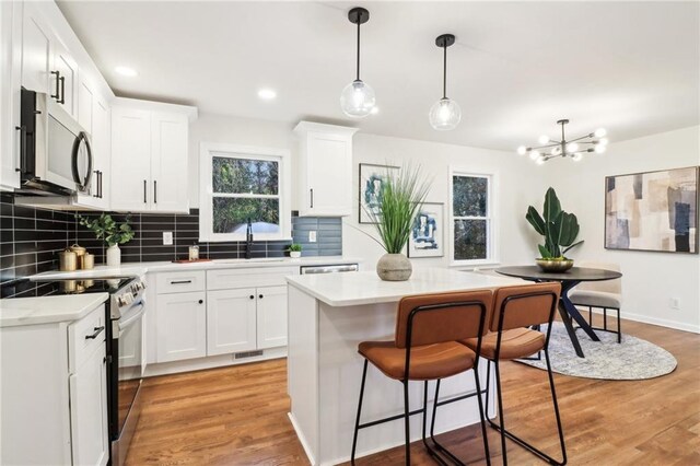 dining space with sink, an inviting chandelier, and light hardwood / wood-style flooring