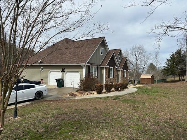 view of home's exterior featuring a yard, concrete driveway, a garage, stone siding, and board and batten siding