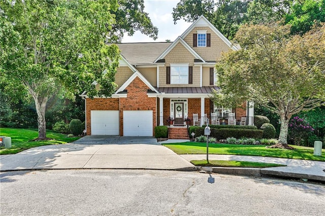 craftsman inspired home with a front yard, covered porch, and a garage