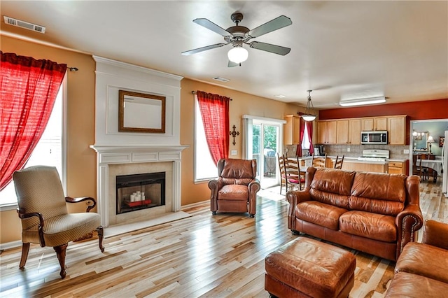 living room with ceiling fan and light wood-type flooring