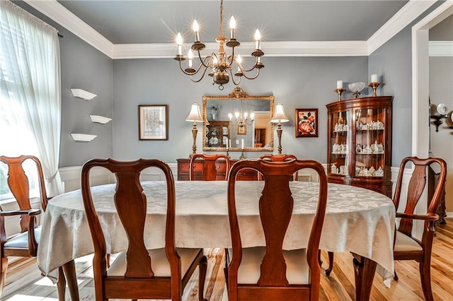 dining space featuring a notable chandelier, light wood-type flooring, and ornamental molding