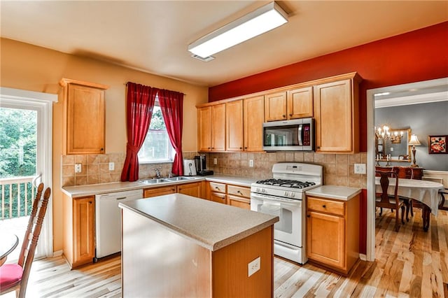 kitchen with backsplash, light wood-type flooring, white appliances, and a wealth of natural light