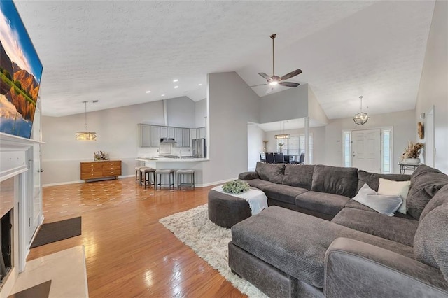 964 Natural Brook Trl, Lawrenceville, GA 30045 - living room with a fireplace with flush hearth, high vaulted ceiling, light wood-type flooring, ceiling fan, and a textured ceiling