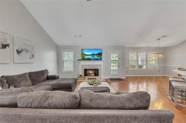 964 Natural Brook Trl, Lawrenceville, GA 30045 - living room featuring plenty of natural light, a glass covered fireplace, wood finished floors, and vaulted ceiling