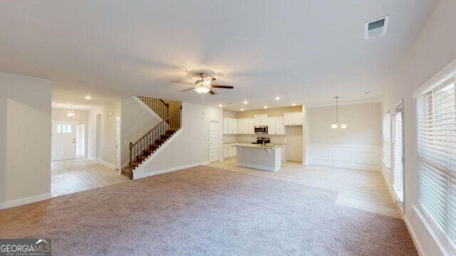 3402 Milan Ct Lot 1Plapprox Sqft 2, Douglasville, GA 30135 - unfurnished living room with light carpet, stairs, a ceiling fan, recessed lighting, and wainscoting