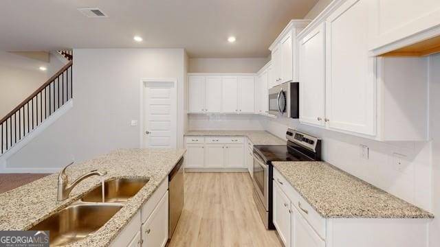 3402 Milan Ct Lot 1Plapprox Sqft 2, Douglasville, GA 30135 - kitchen with stainless steel appliances, white cabinetry, light stone counters, light wood-type flooring, and recessed lighting