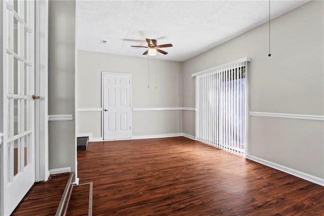 empty room featuring ceiling fan and dark wood-type flooring