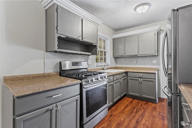 kitchen featuring gray cabinetry, decorative backsplash, and stainless steel appliances