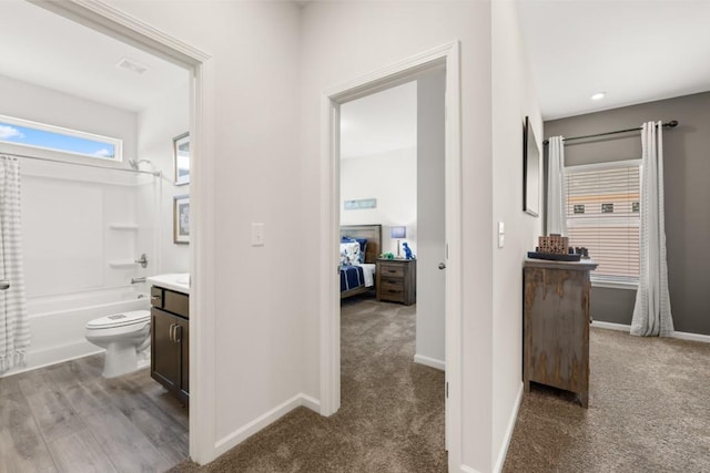 full bathroom with toilet, vanity, hardwood / wood-style floors, and washtub / shower combination