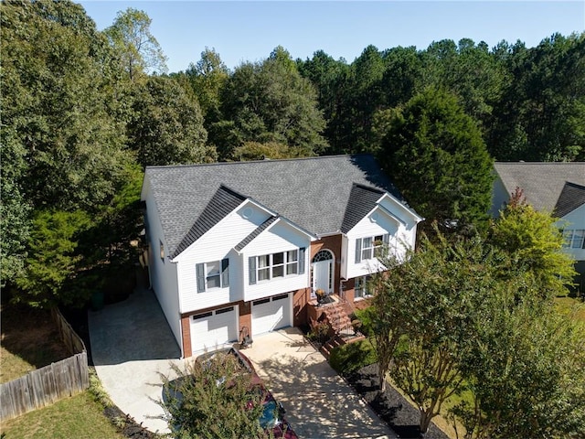 3265 Bethesda Park Ct, Lawrenceville, GA 30044 - split foyer home featuring driveway, fence, an attached garage, roof with shingles, and a forest view