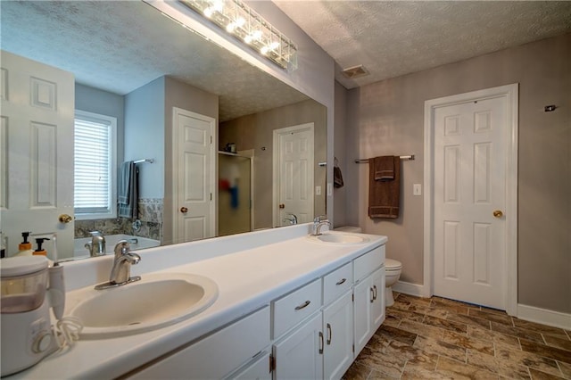 3265 Bethesda Park Ct, Lawrenceville, GA 30044 - full bathroom featuring a textured ceiling, double vanity, a shower stall, toilet, and baseboards