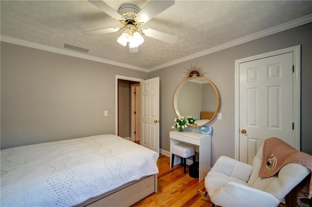 3265 Bethesda Park Ct, Lawrenceville, GA 30044 - bedroom with light wood finished floors, ornamental molding, a ceiling fan, and a textured ceiling