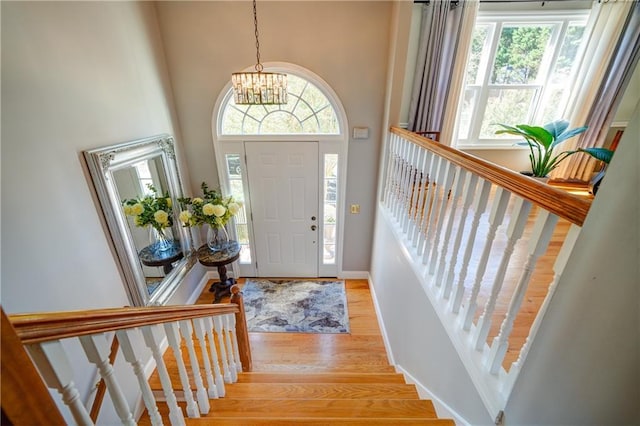 3265 Bethesda Park Ct, Lawrenceville, GA 30044 - entryway with light wood-style flooring, a chandelier, baseboards, a high ceiling, and stairs